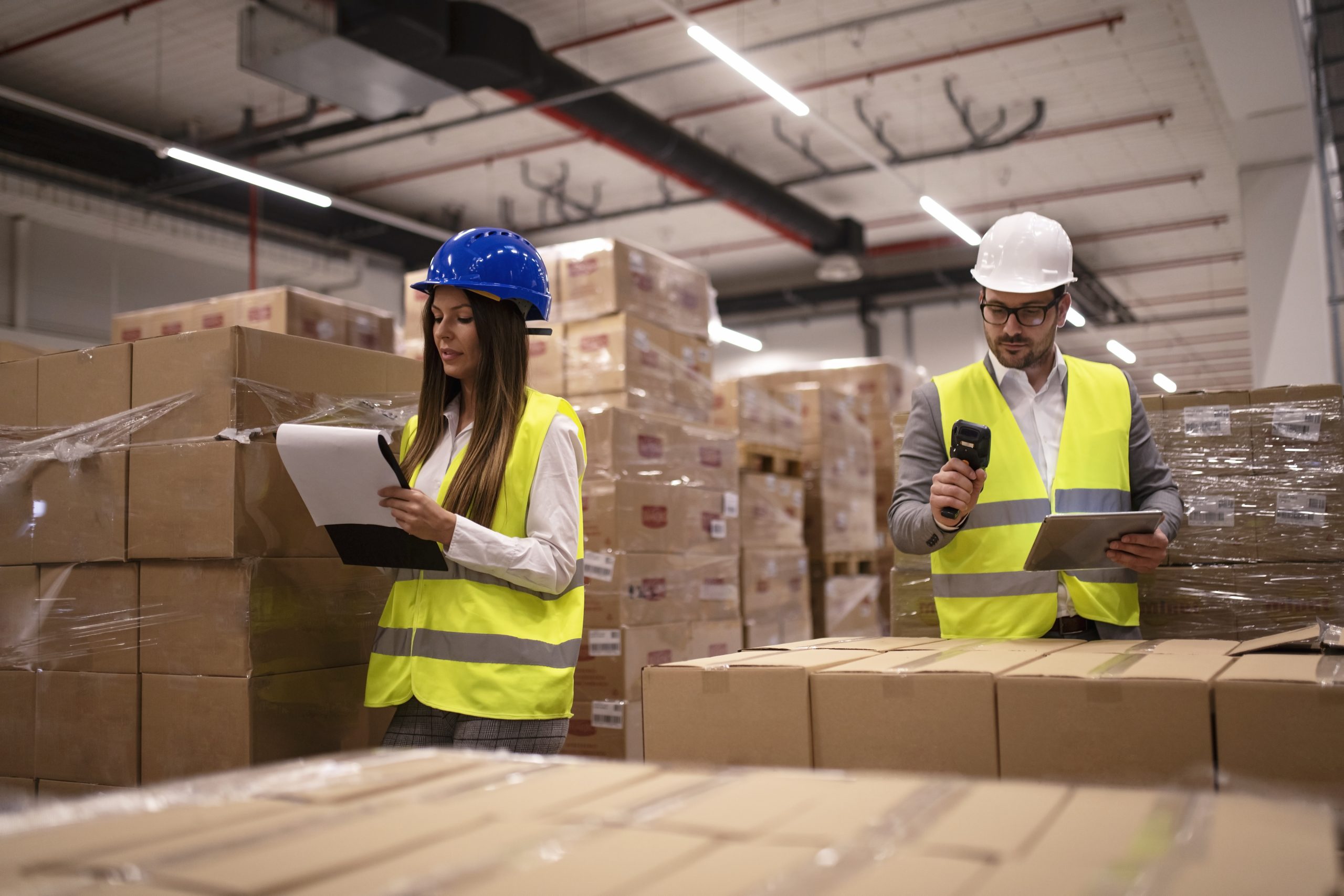 warehouse workers using bar code scanner and tablet and checking goods inventory.